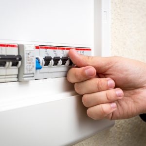 Close up of man switching circuit breaker